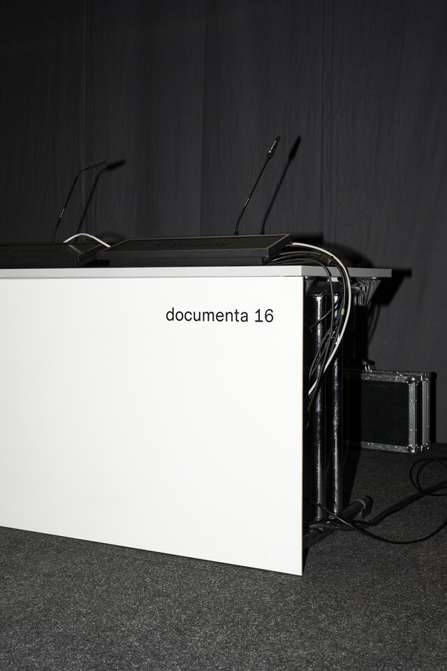 A speakers podium can be seen, on the front is written documenta 16